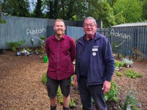Two men standing in a garden